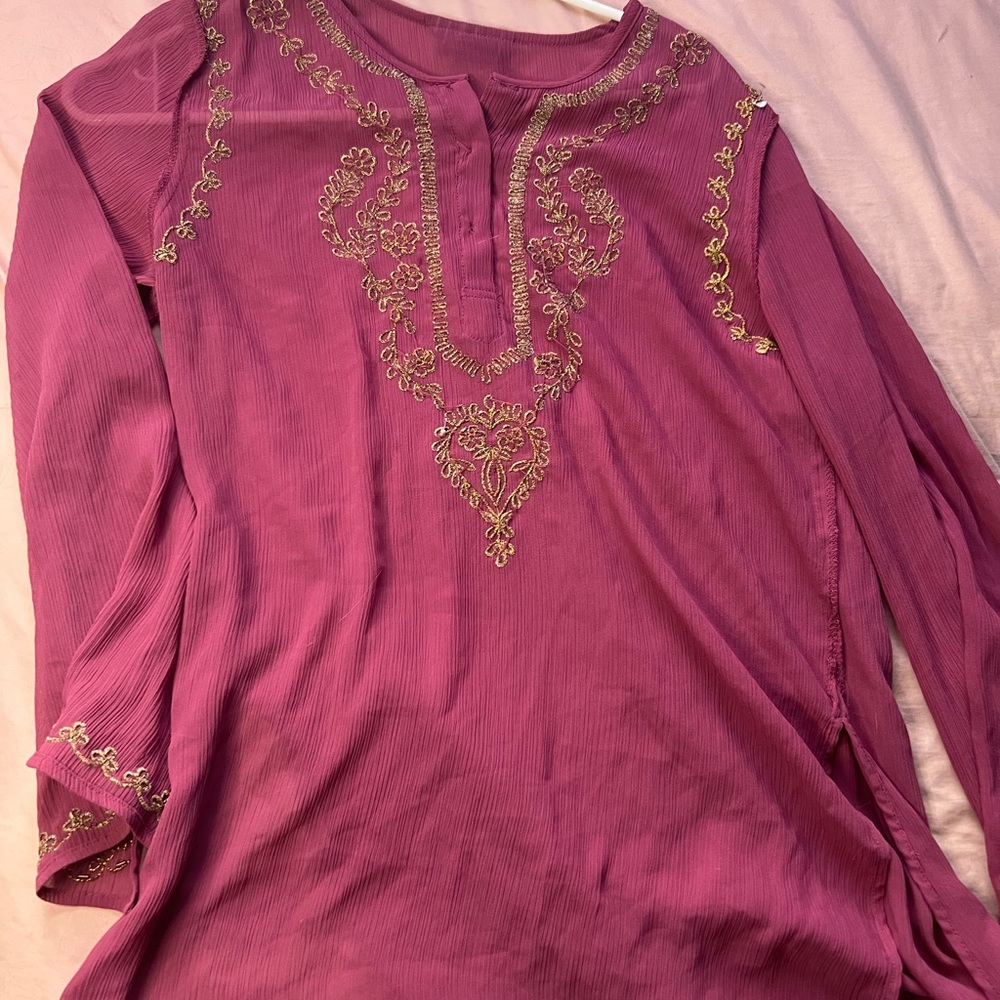 Gold and pink shirt with a design . Thin material and it’s a long sleeve .